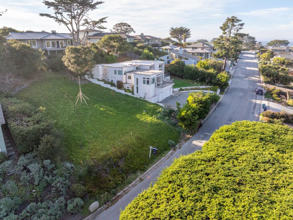 Carmel vacant lot aerial view showing surrounding neighborhood and coastal landscape